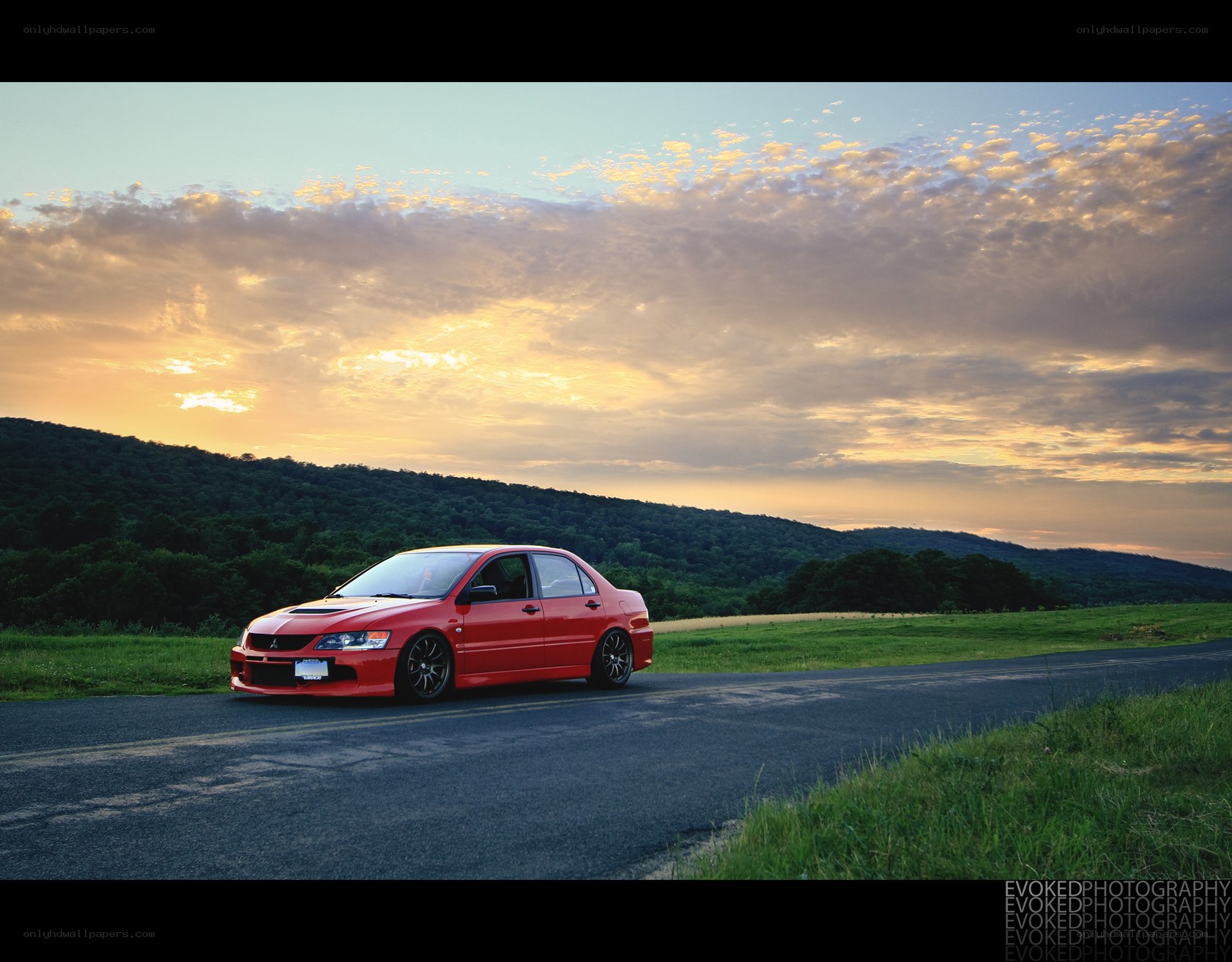 Red car on road at sunset