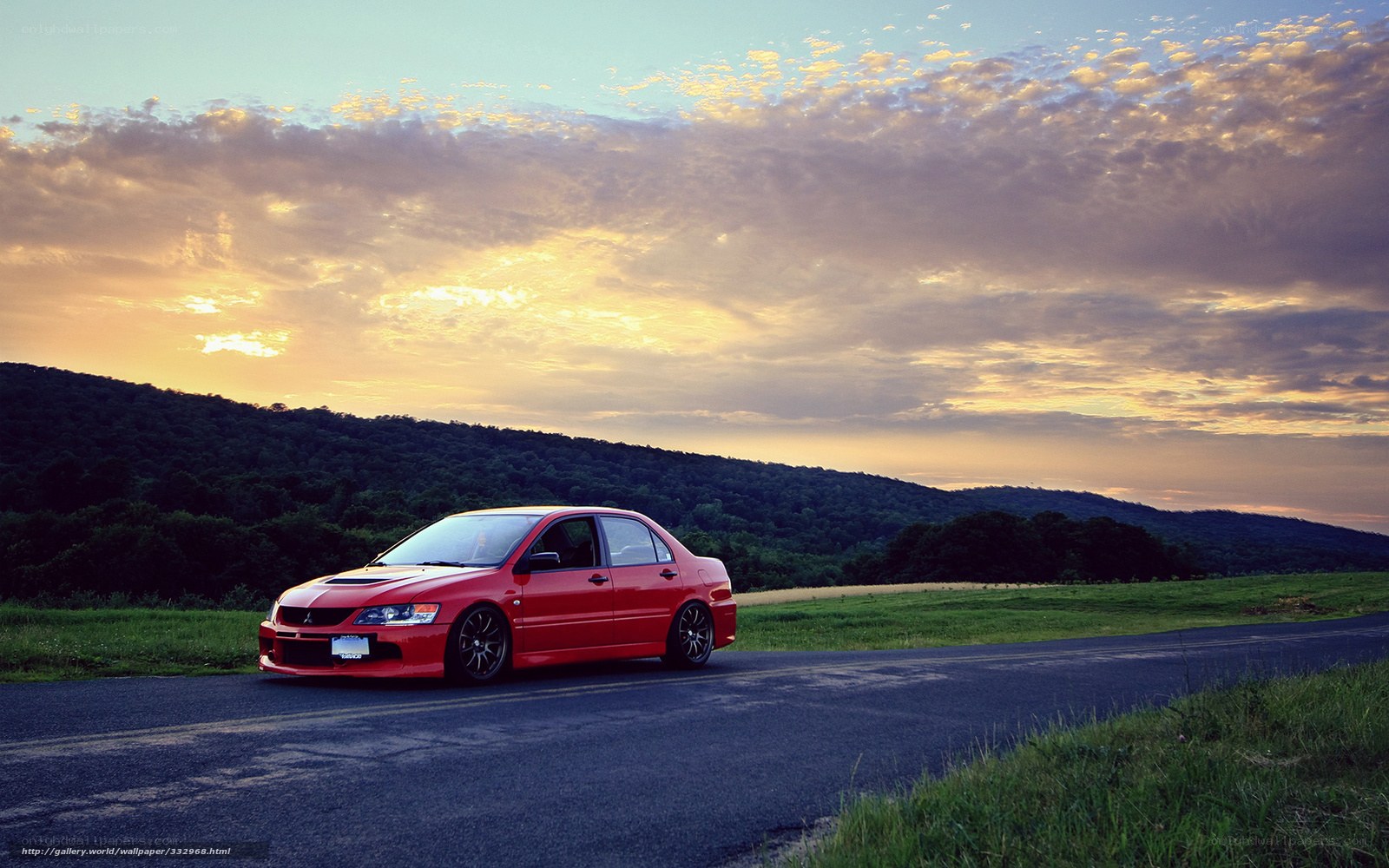 Red car on road at sunset