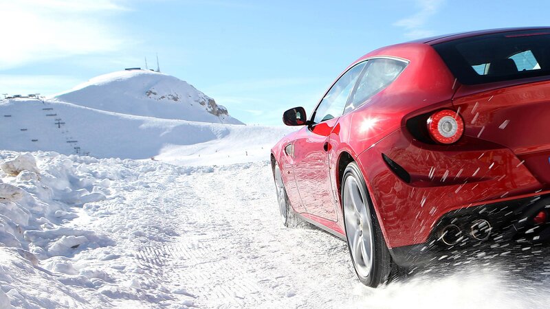Red car on snowy mountain road