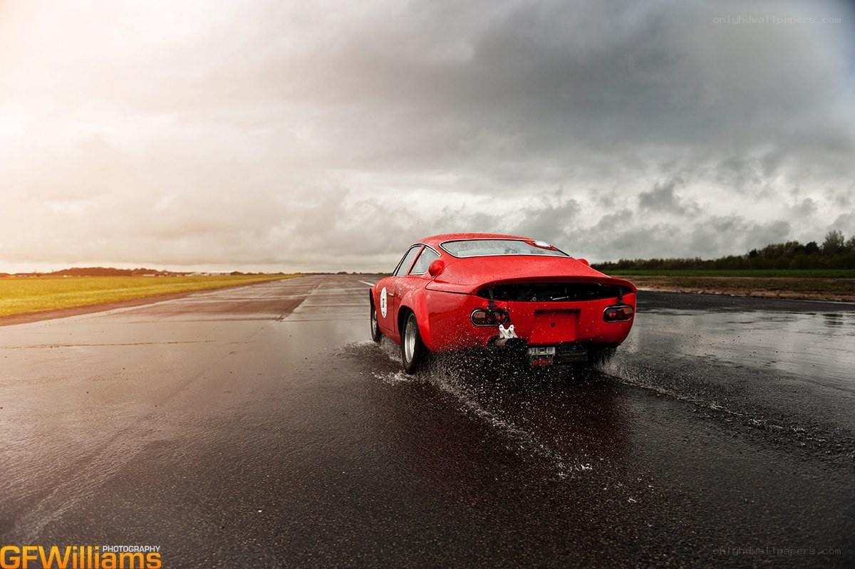 Red car on wet runway
