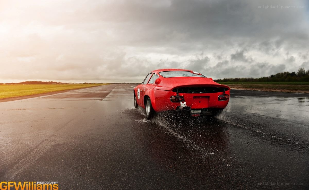 Red car on wet runway