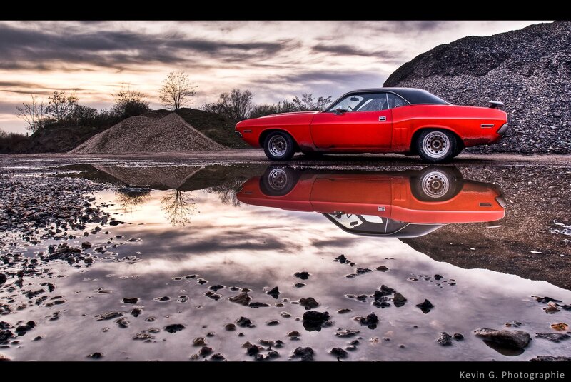 Red car reflected in a puddle