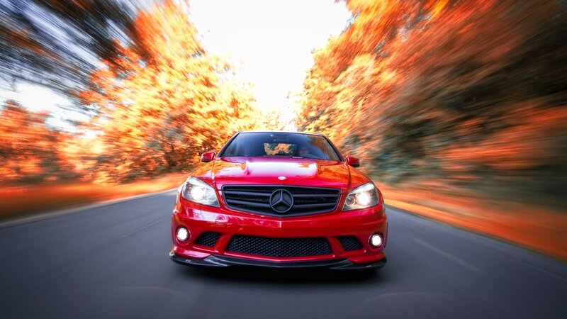 Red car speeding on autumn road