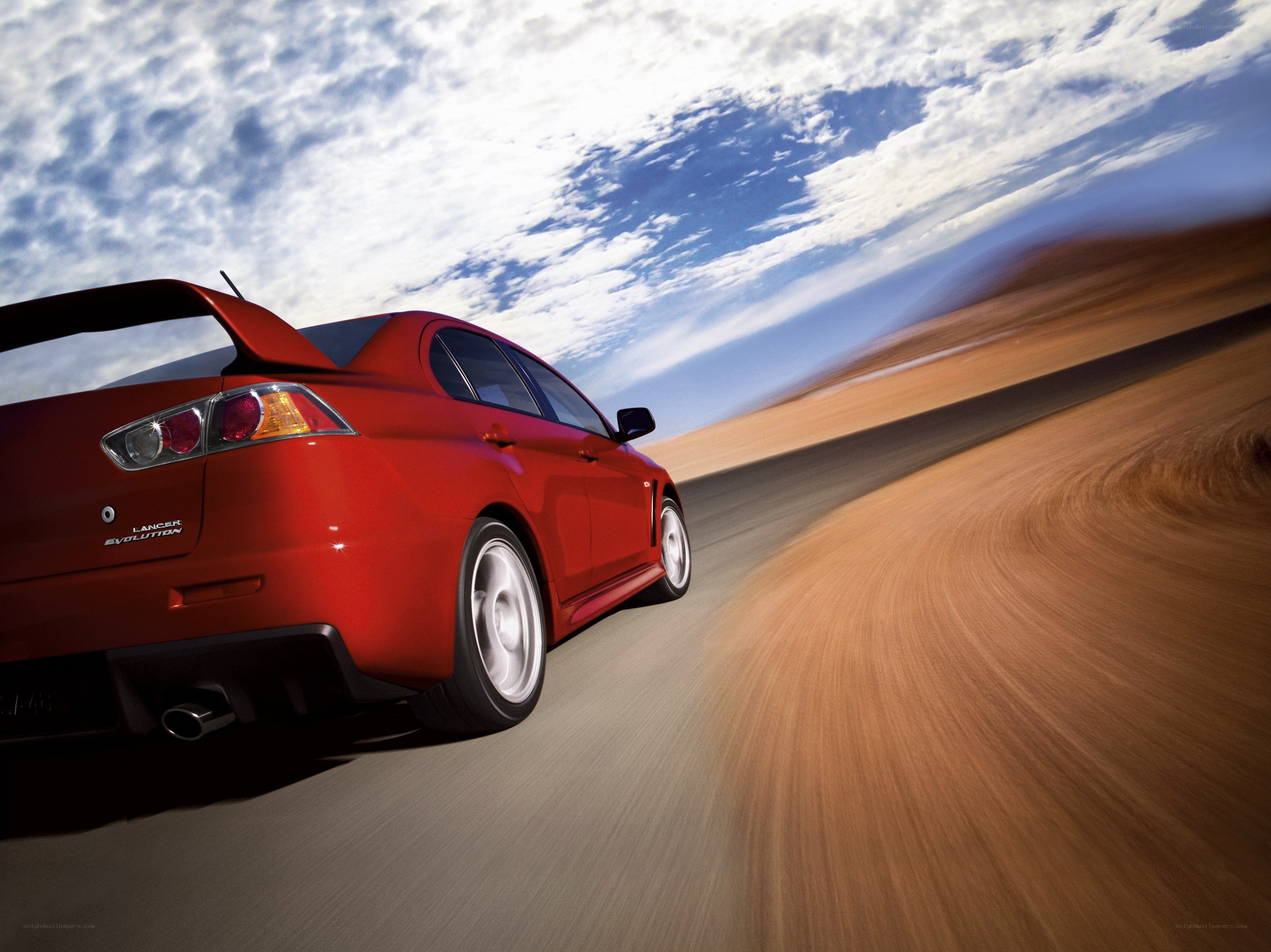 Red car speeding on desert road
