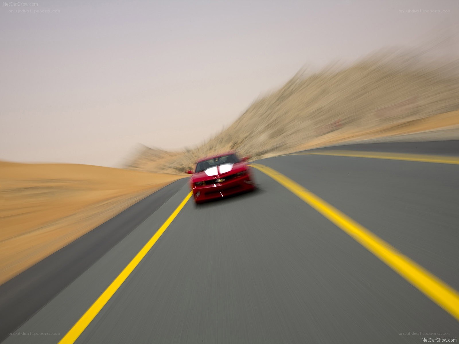Red car speeding on desert road