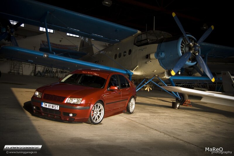 Red car under a biplane