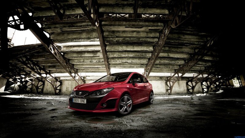 Red car under a bridge