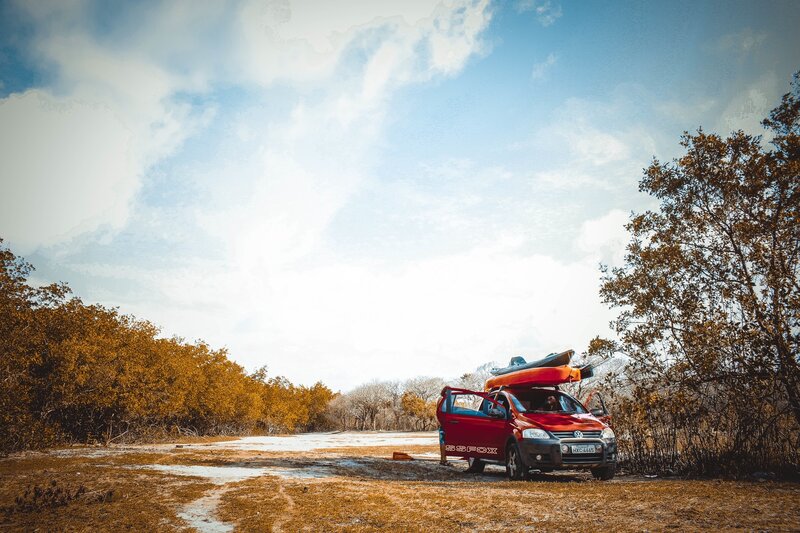 Red car with kayak in nature