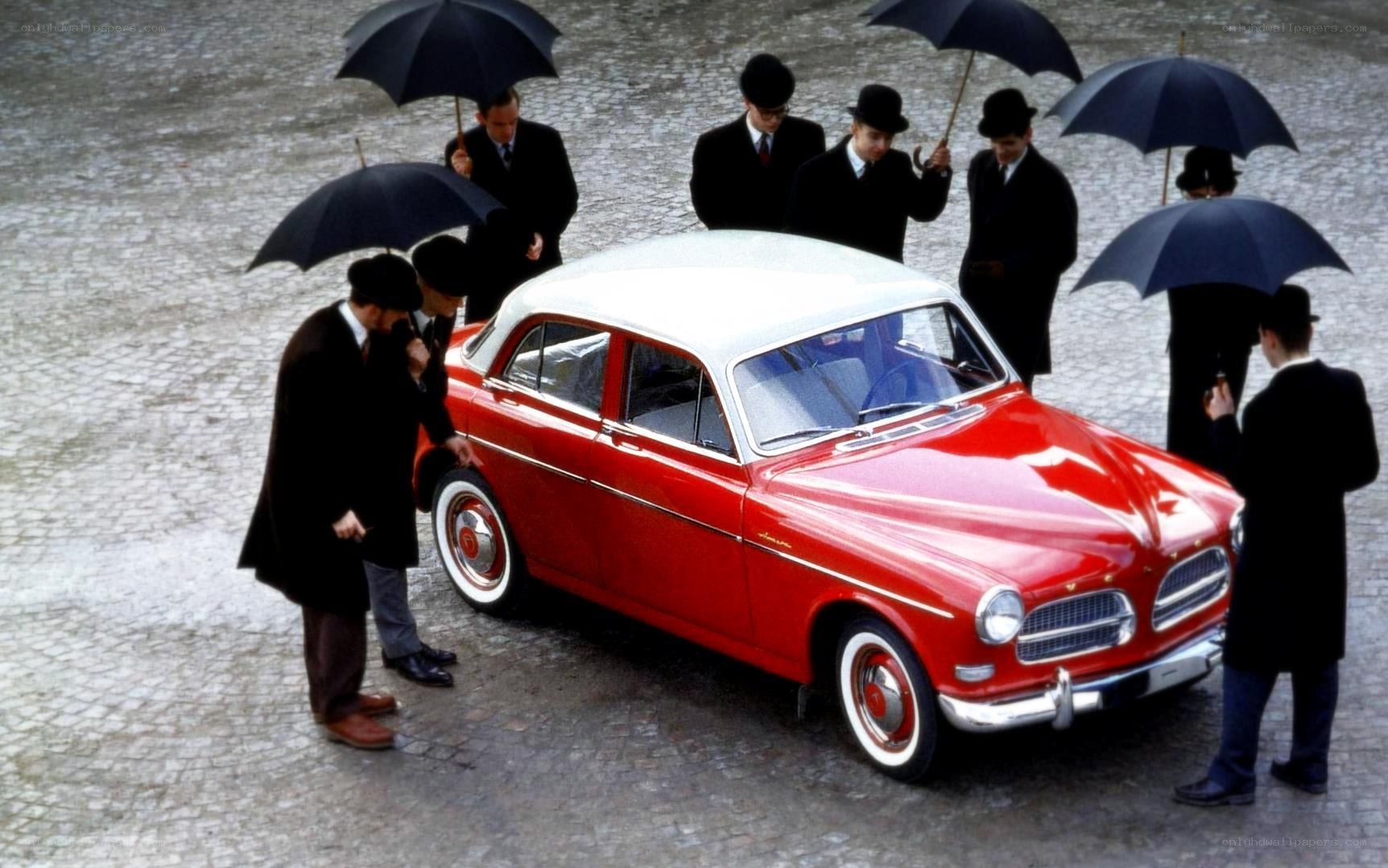 Red car with men holding umbrellas