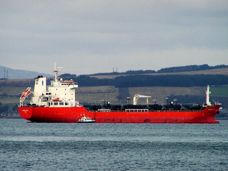 Red cargo ship in harbor