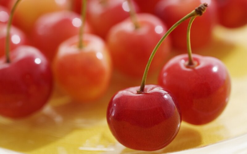 Red Cherries on Yellow Surface