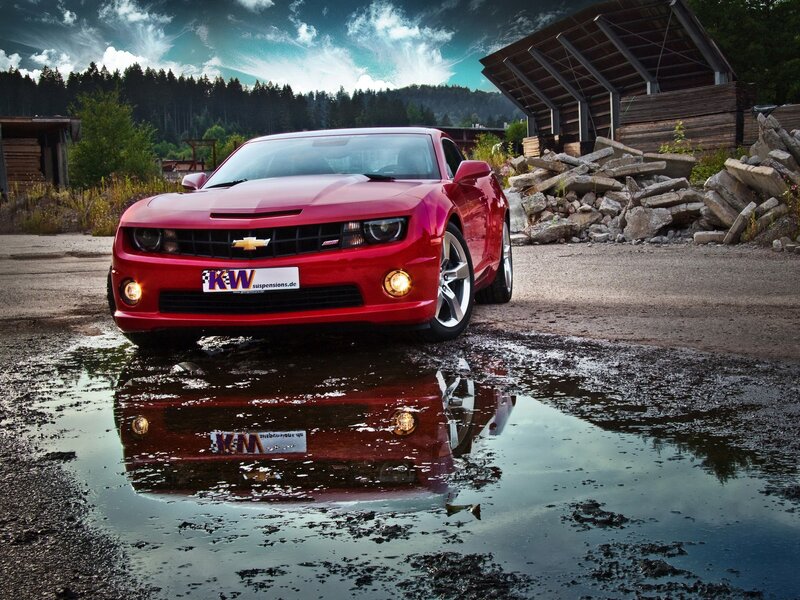 Red Chevrolet Camaro in puddle