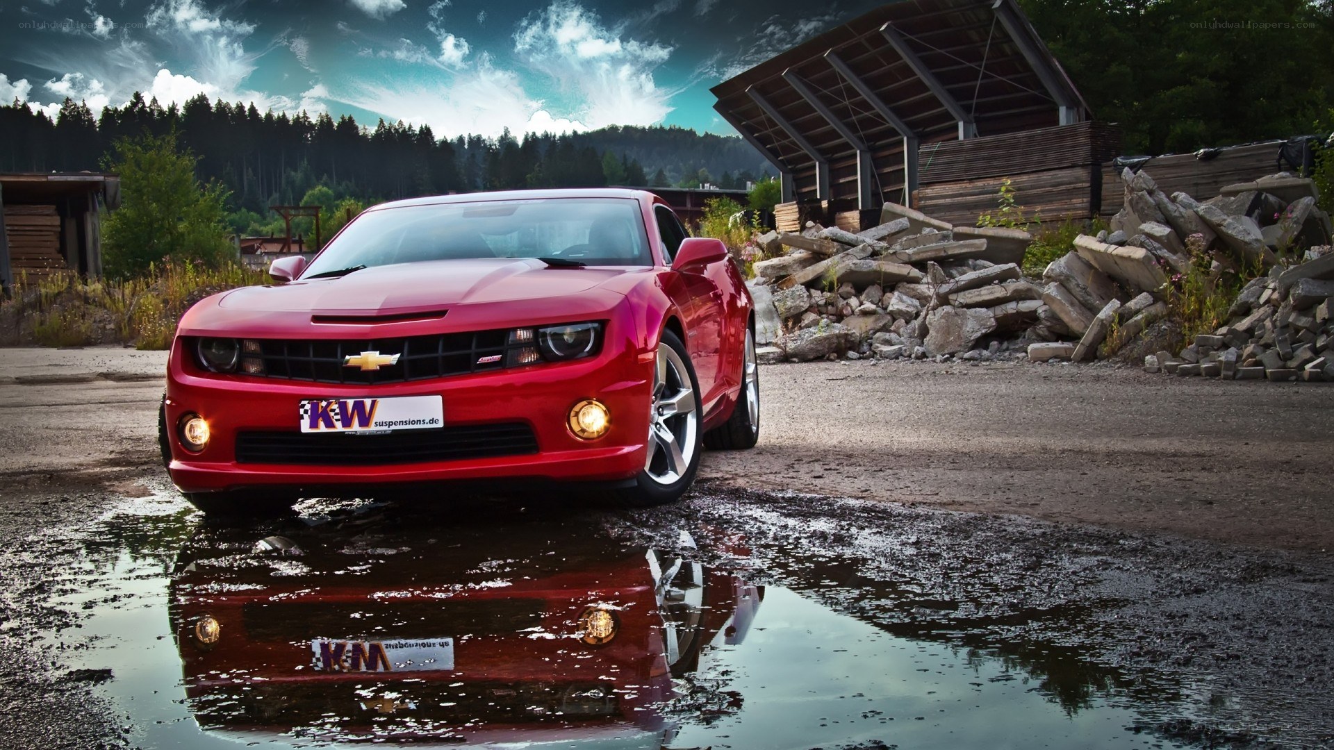 Red Chevrolet Camaro in puddle
