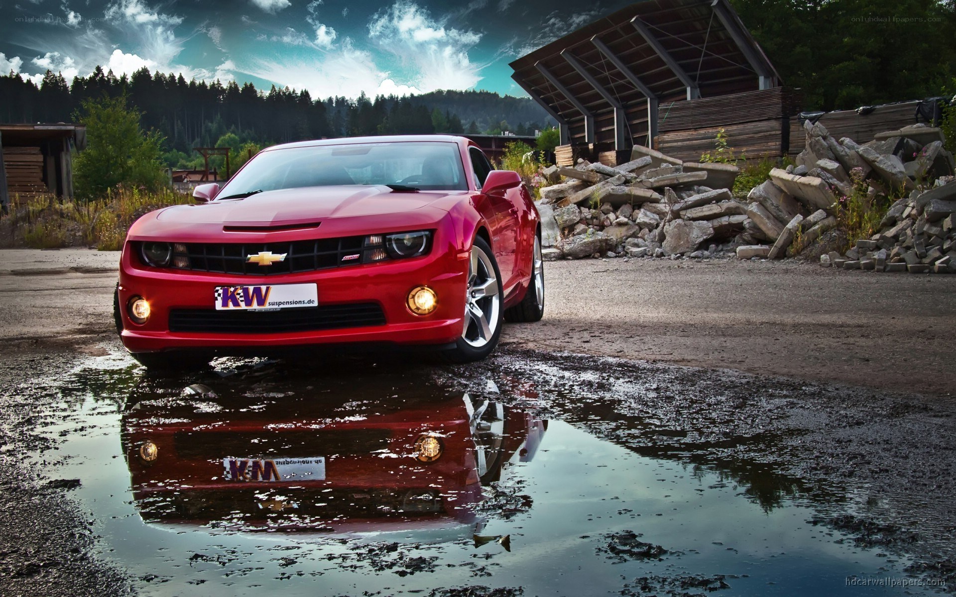 Red Chevrolet Camaro in puddle