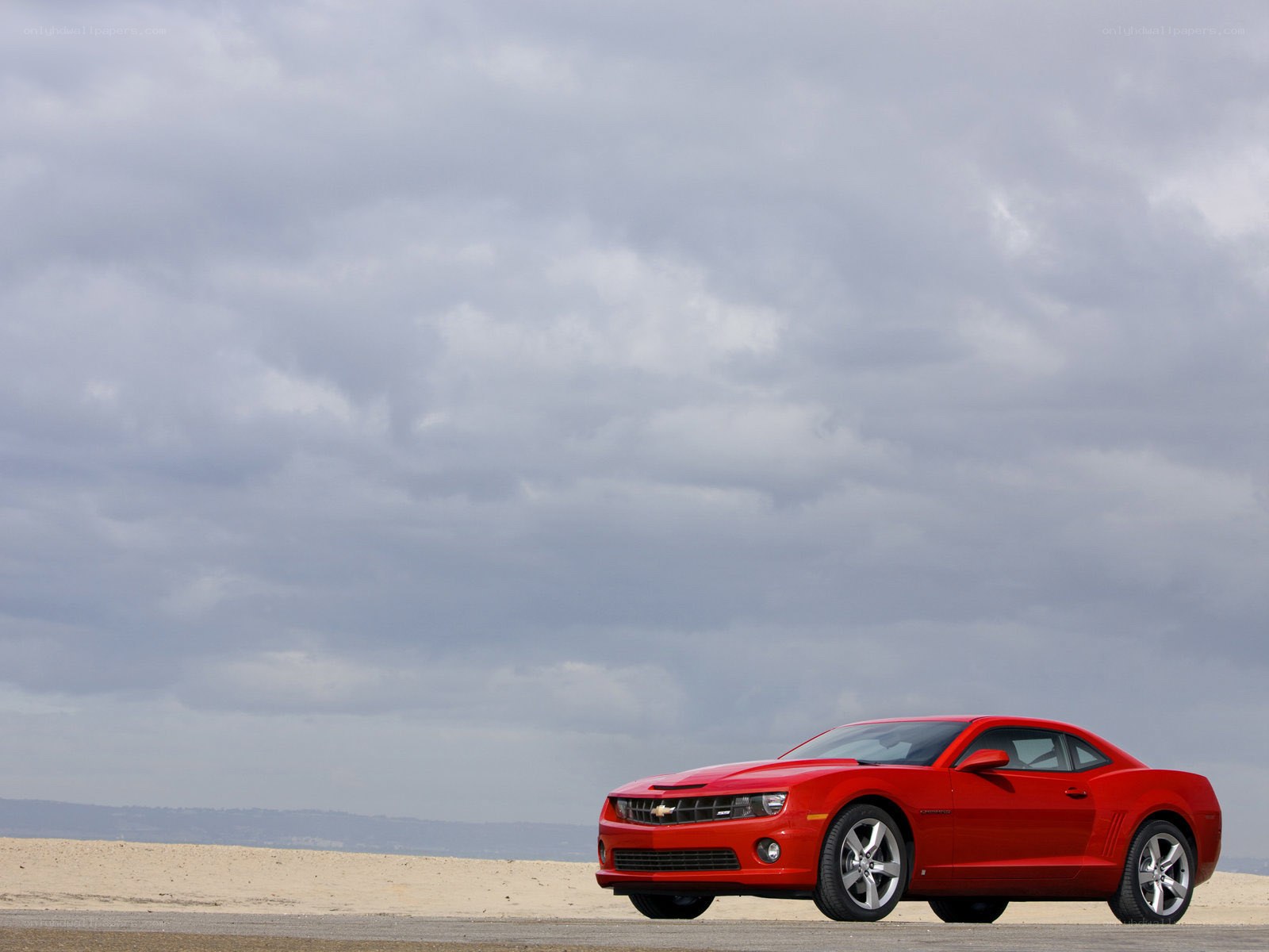 Red Chevrolet Camaro on beach