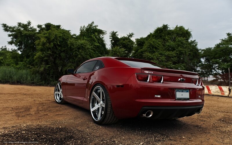 Red Chevrolet Camaro on dirt