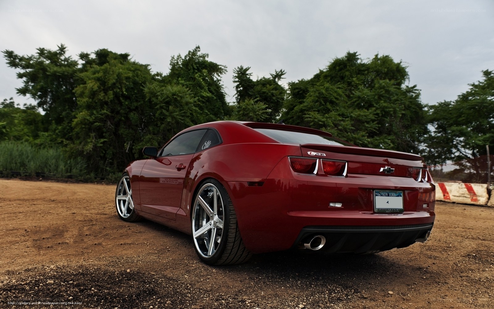 Red Chevrolet Camaro on dirt
