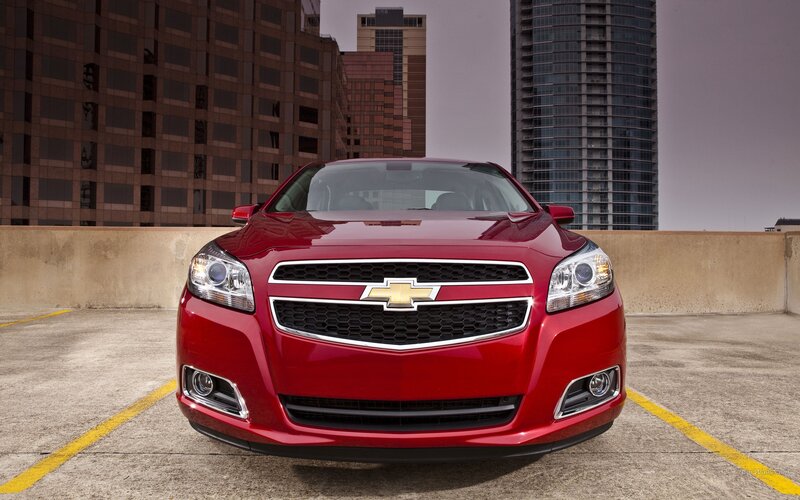 Red Chevrolet Malibu in city parking