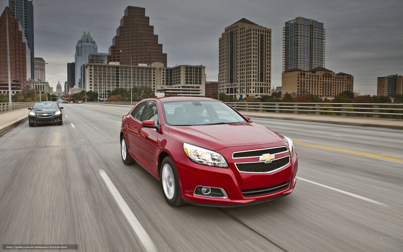 Red Chevrolet Malibu on city bridge