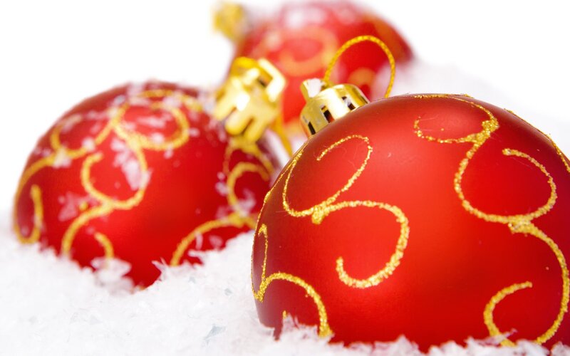 Red Christmas ornaments in snow