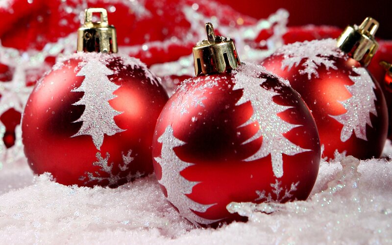 Red Christmas ornaments in snow