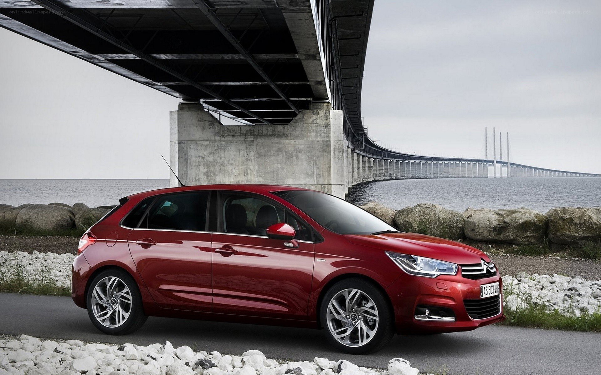 Red Citroën C4 parked under a bridge