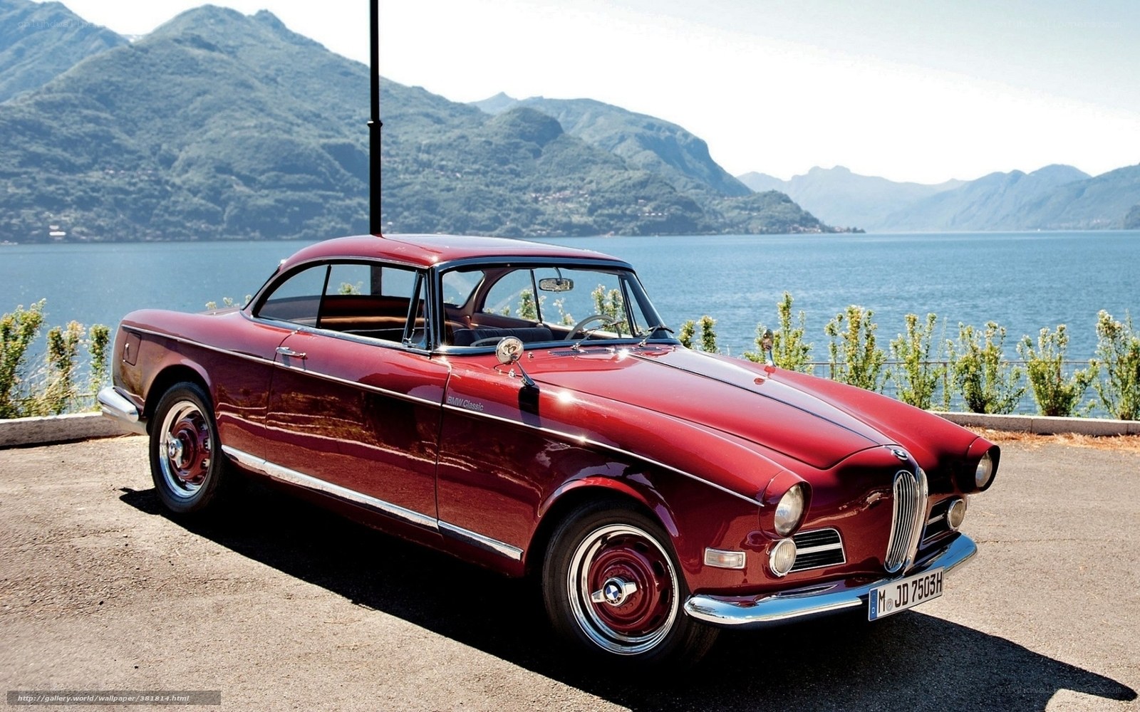 Red classic car by the lake