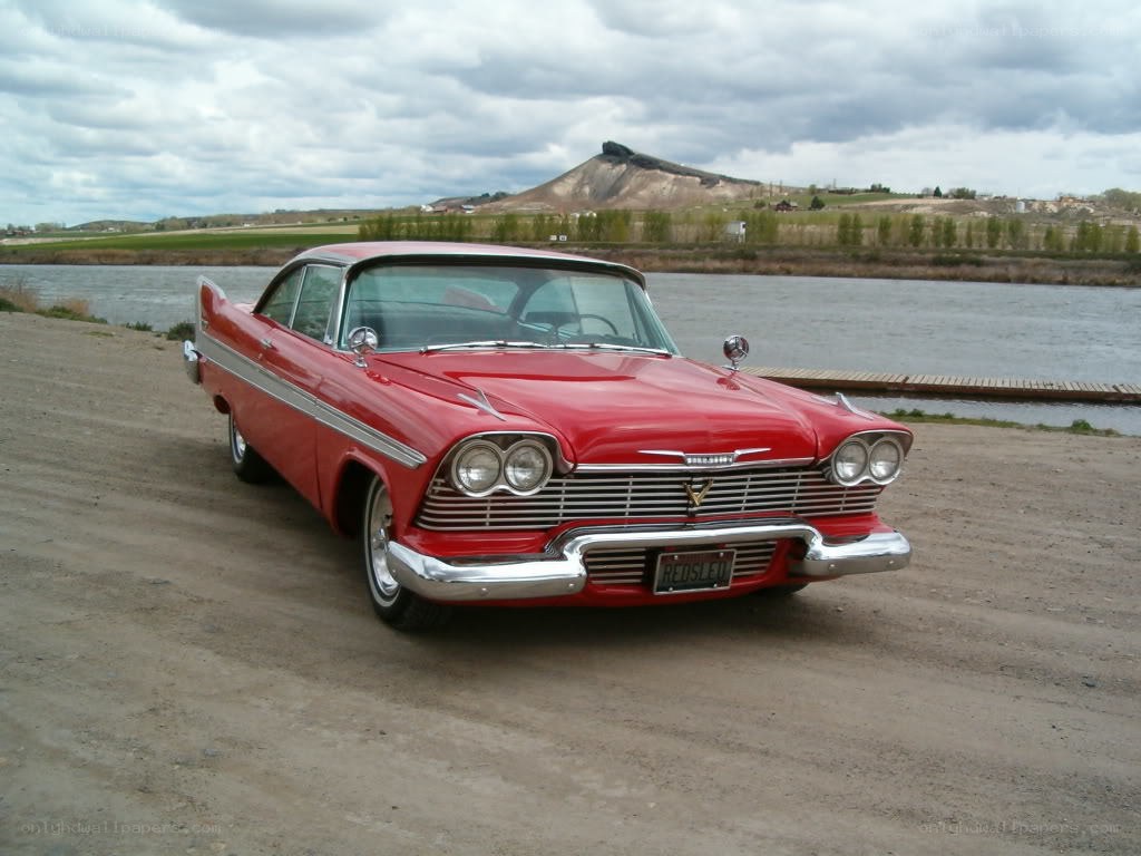 Red classic car by the river