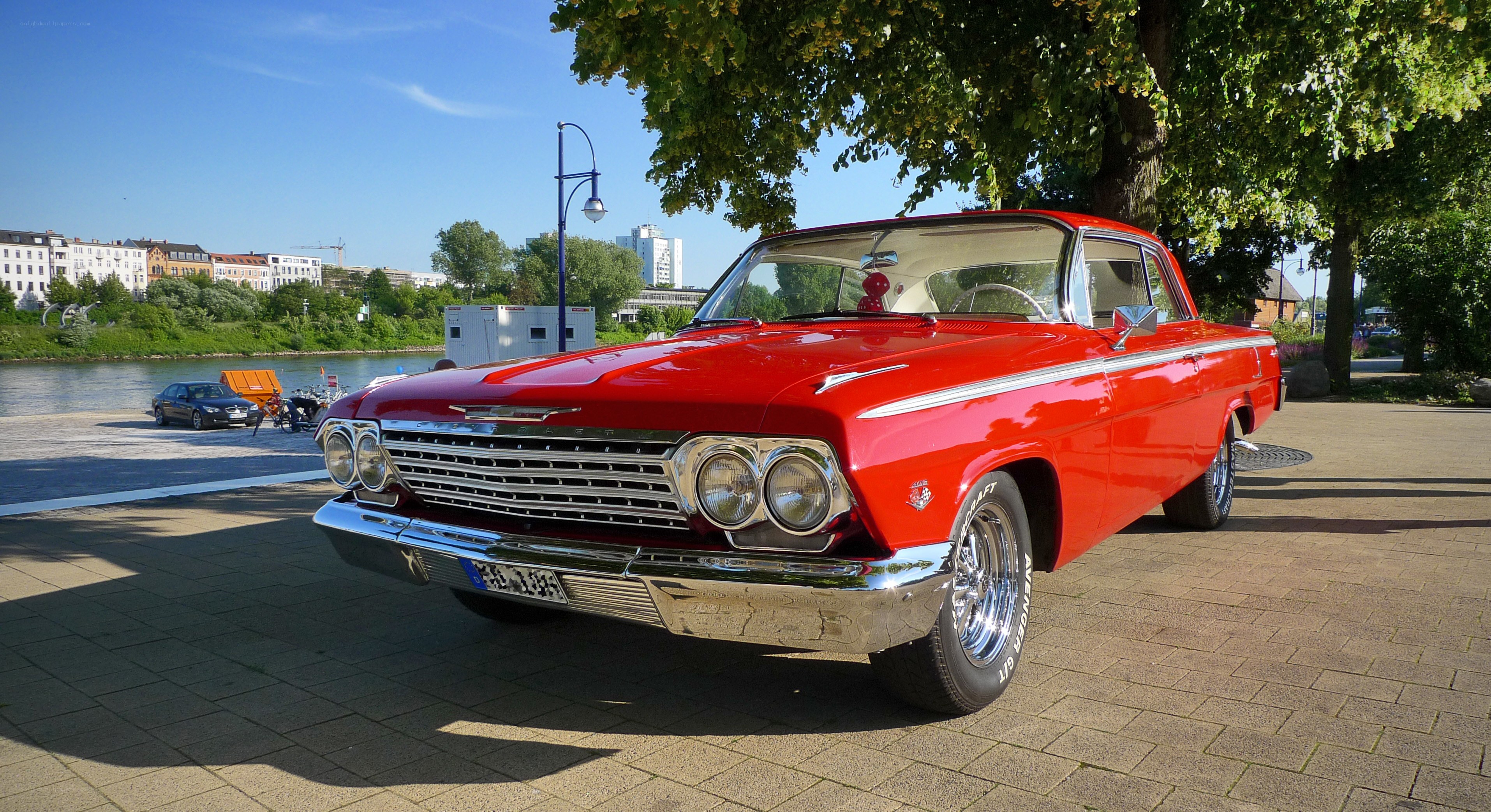 Red classic car by the river