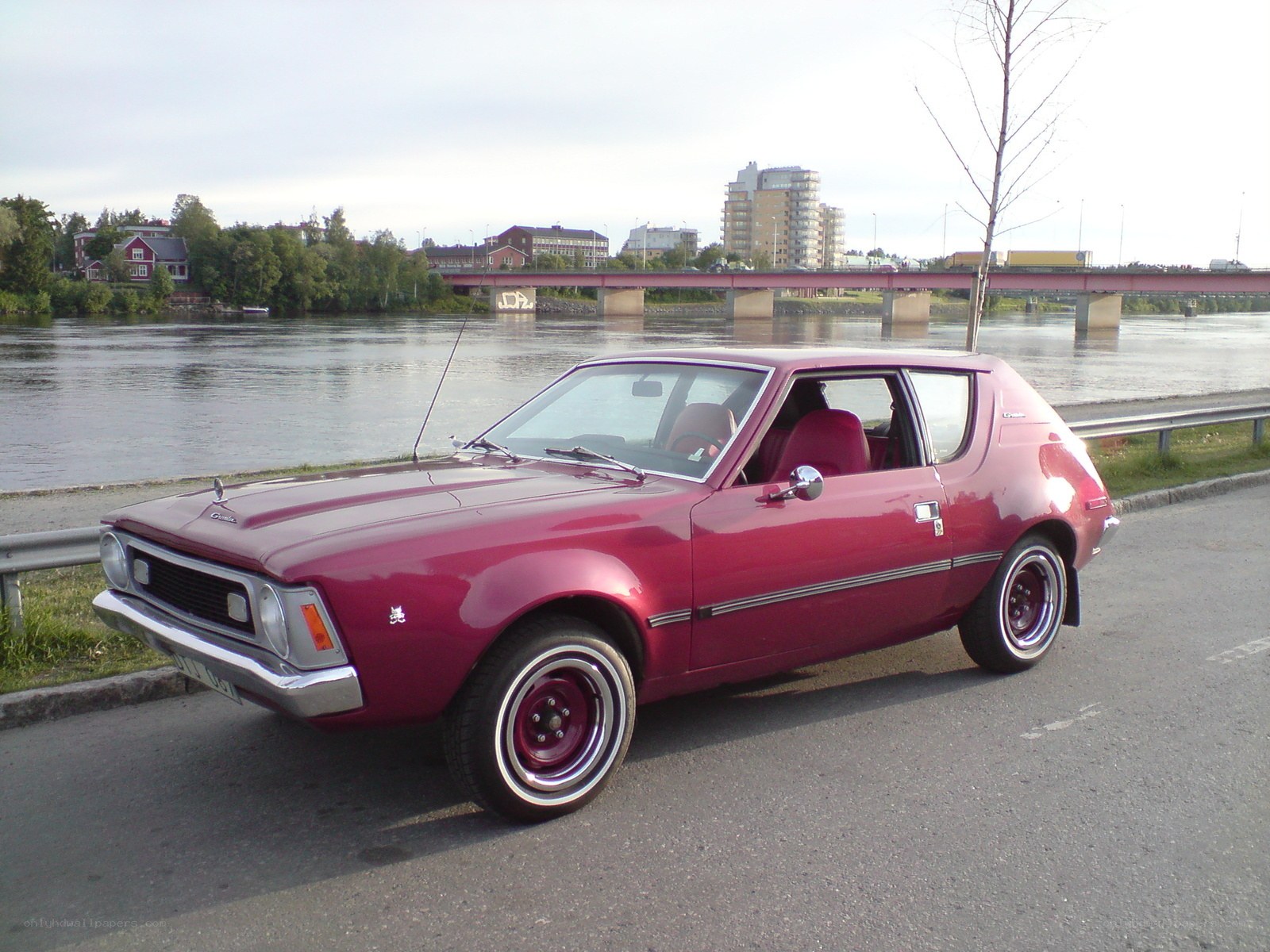 Red classic car by the river