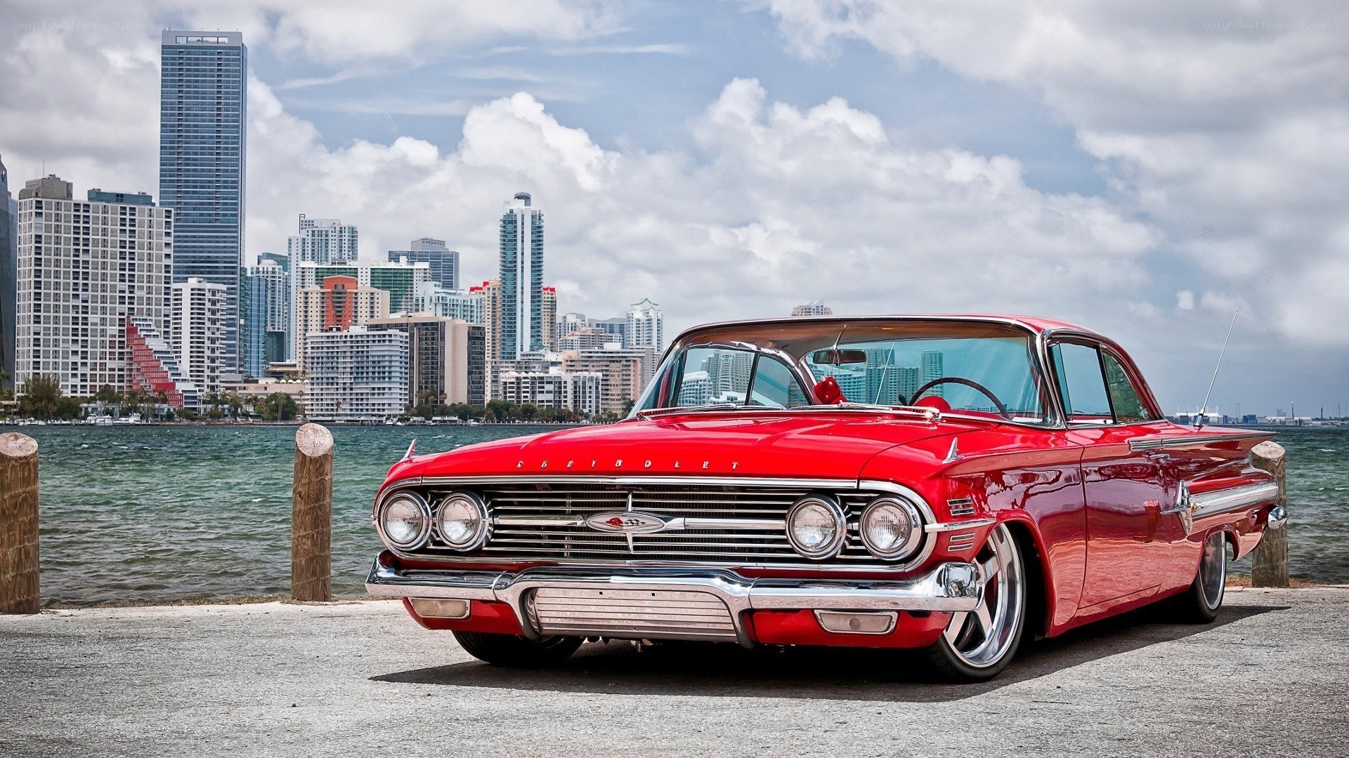 Red classic car by the waterfront