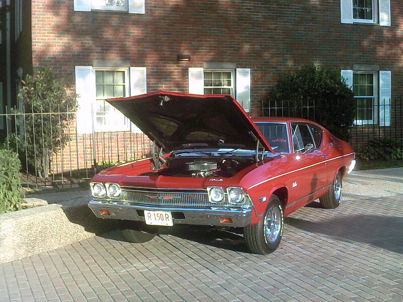 Red Classic Car — Calm, Afternoon, Photograph, Brick Building, Fence