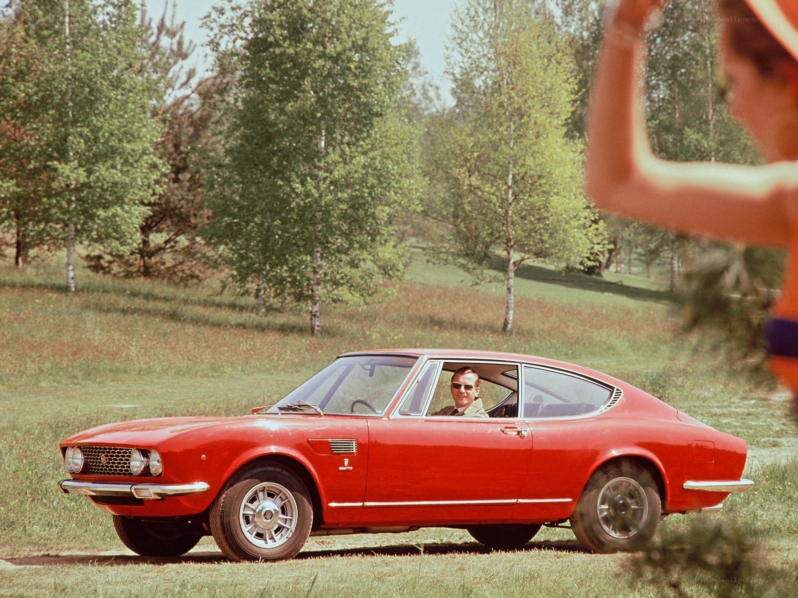 Red classic car in a field