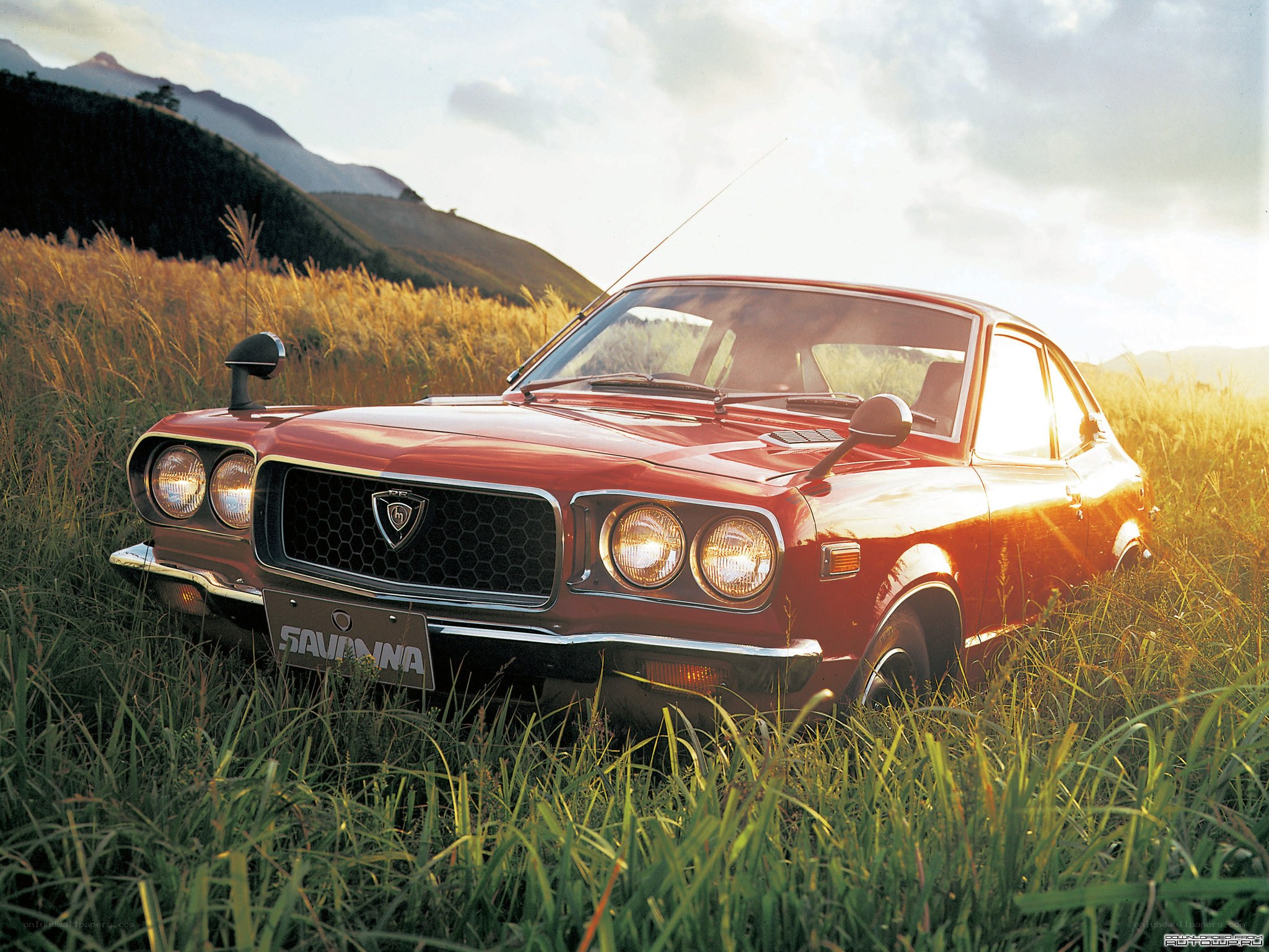 Red classic car in a field