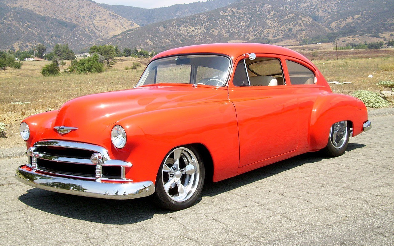 Red classic car in field
