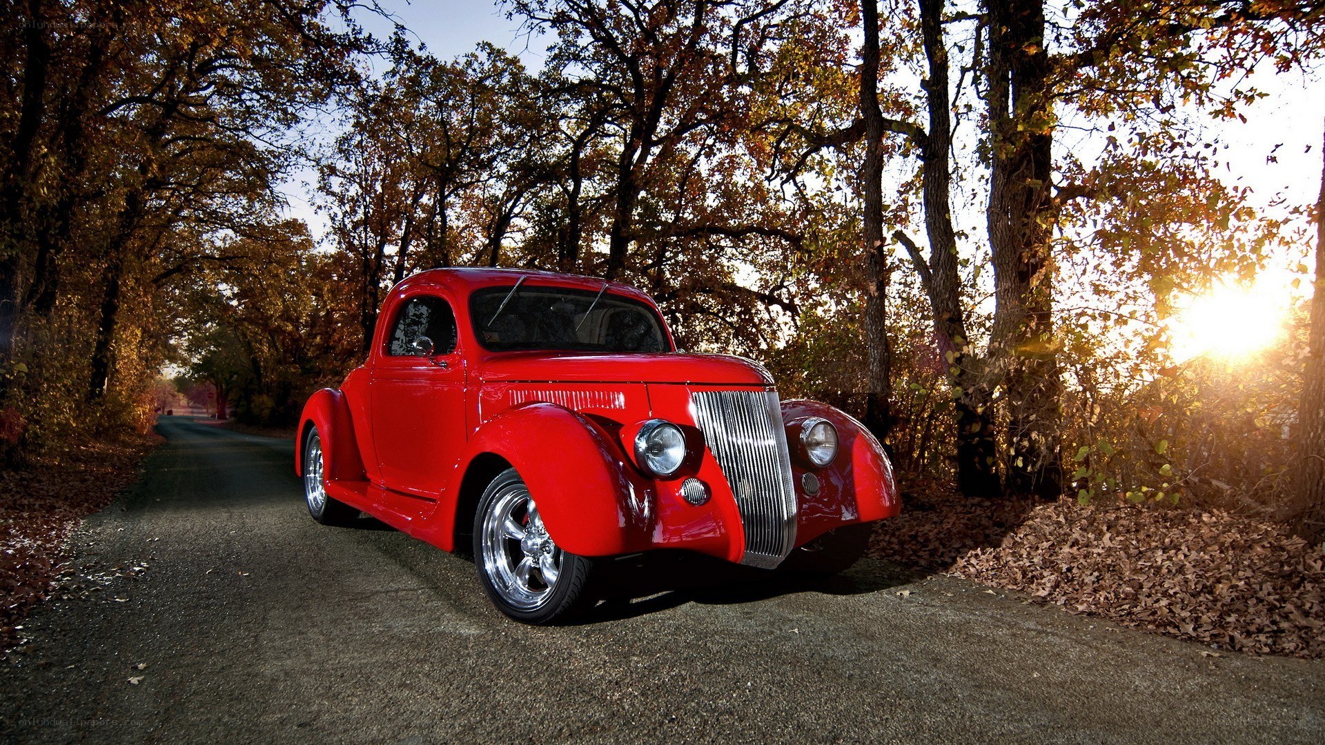 Red classic car on a forest road