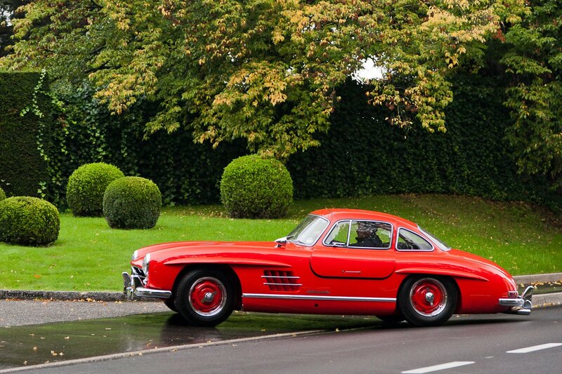 Red classic car on a wet road