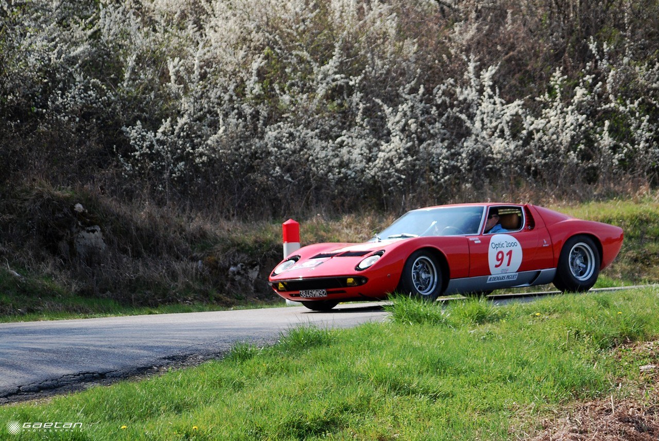 Red classic car on a winding road