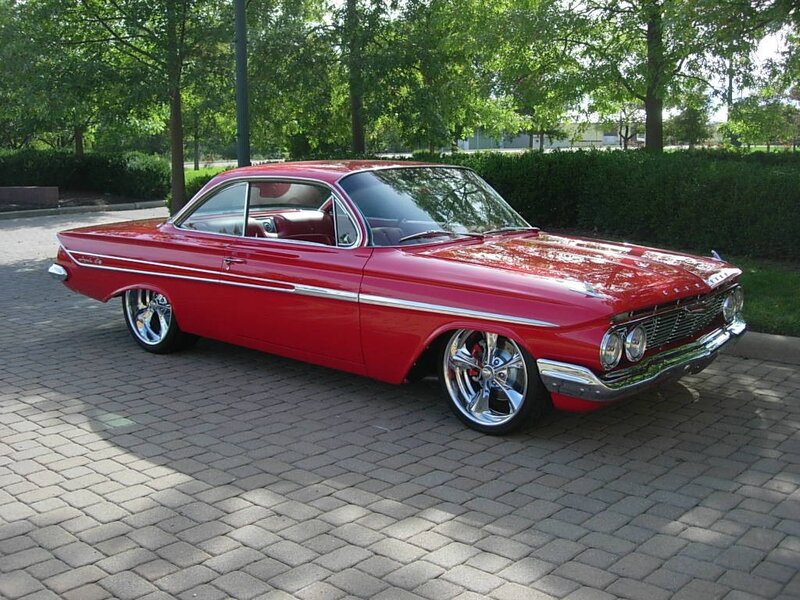 Red classic car on brick pavement