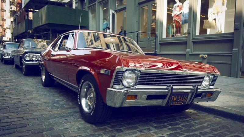 Red classic car on cobblestone street