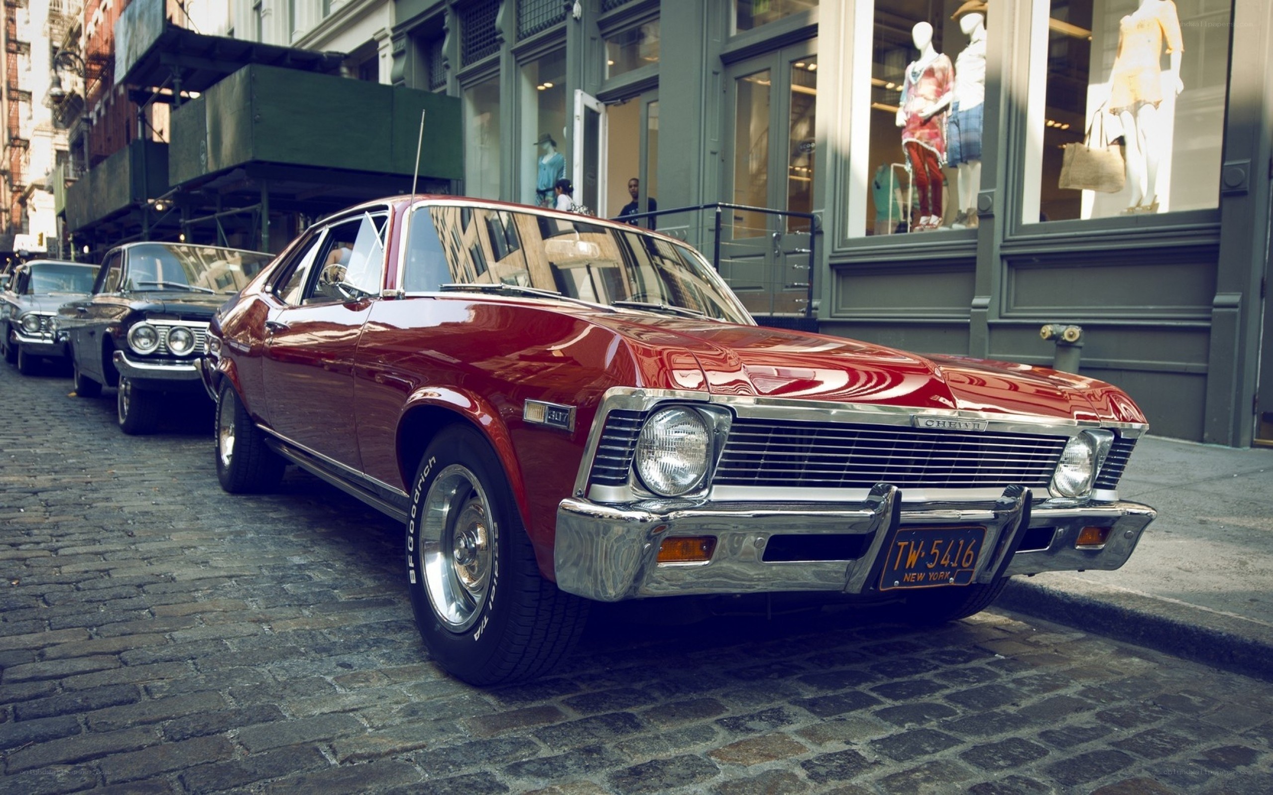 Red classic car on cobblestone street