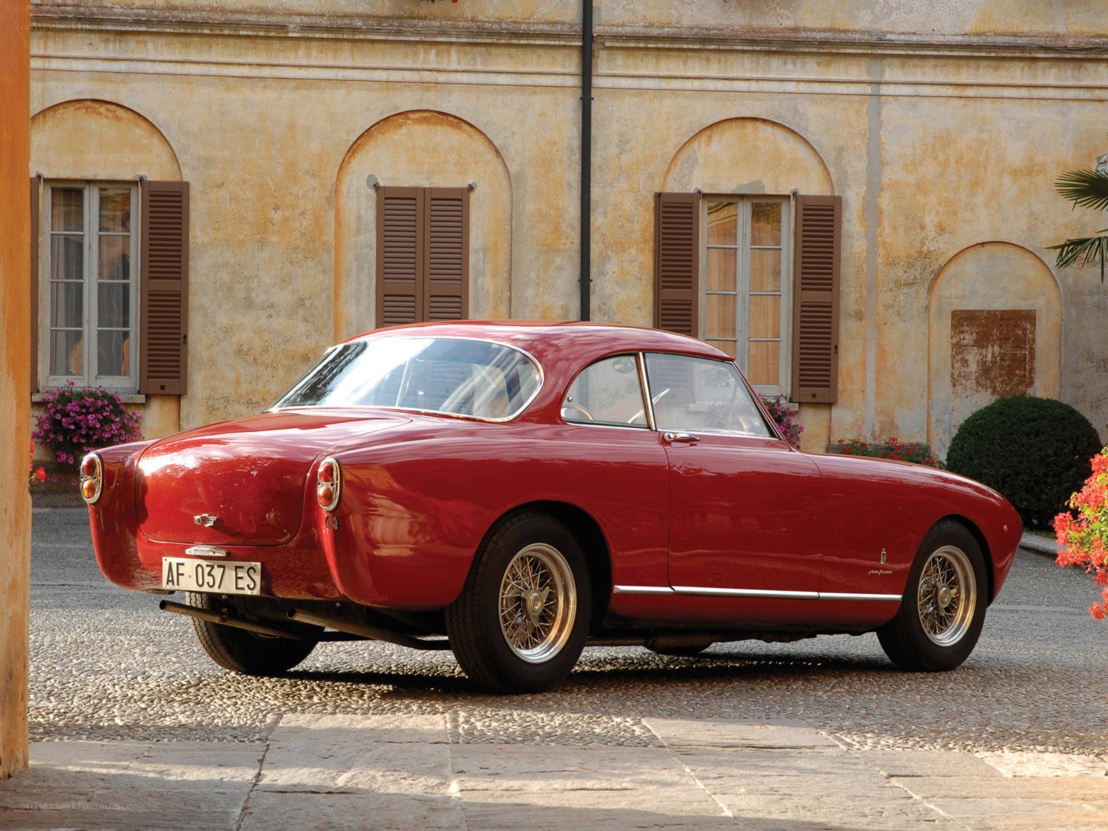 Red classic car on cobblestone