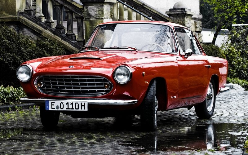 Red classic car on cobblestones