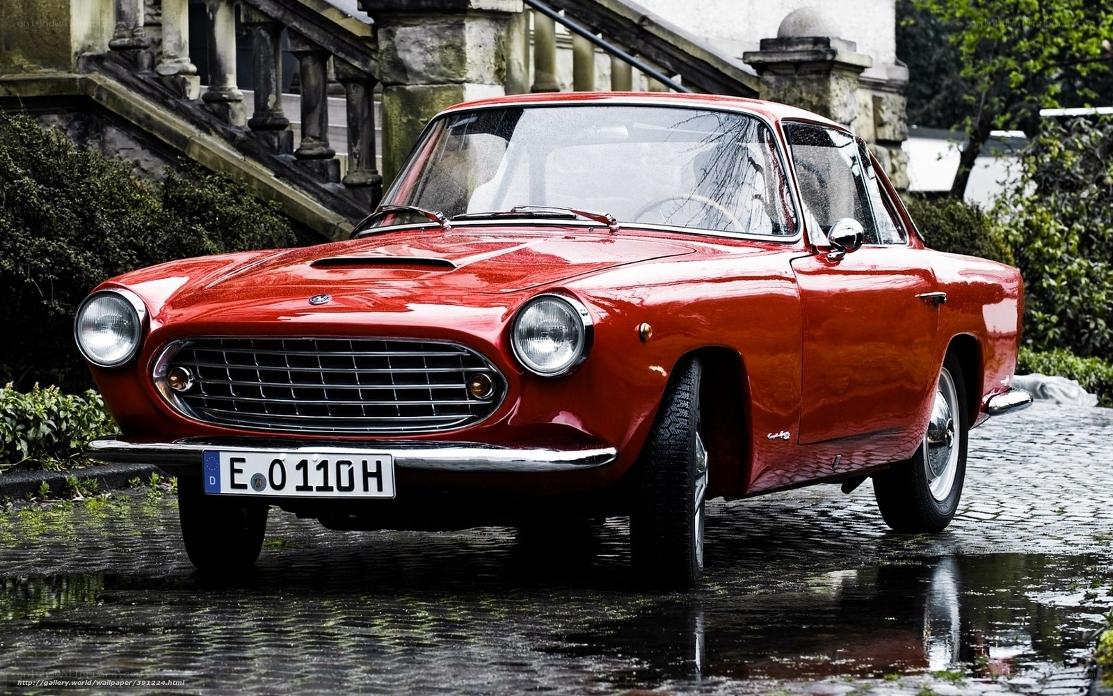 Red classic car on cobblestones