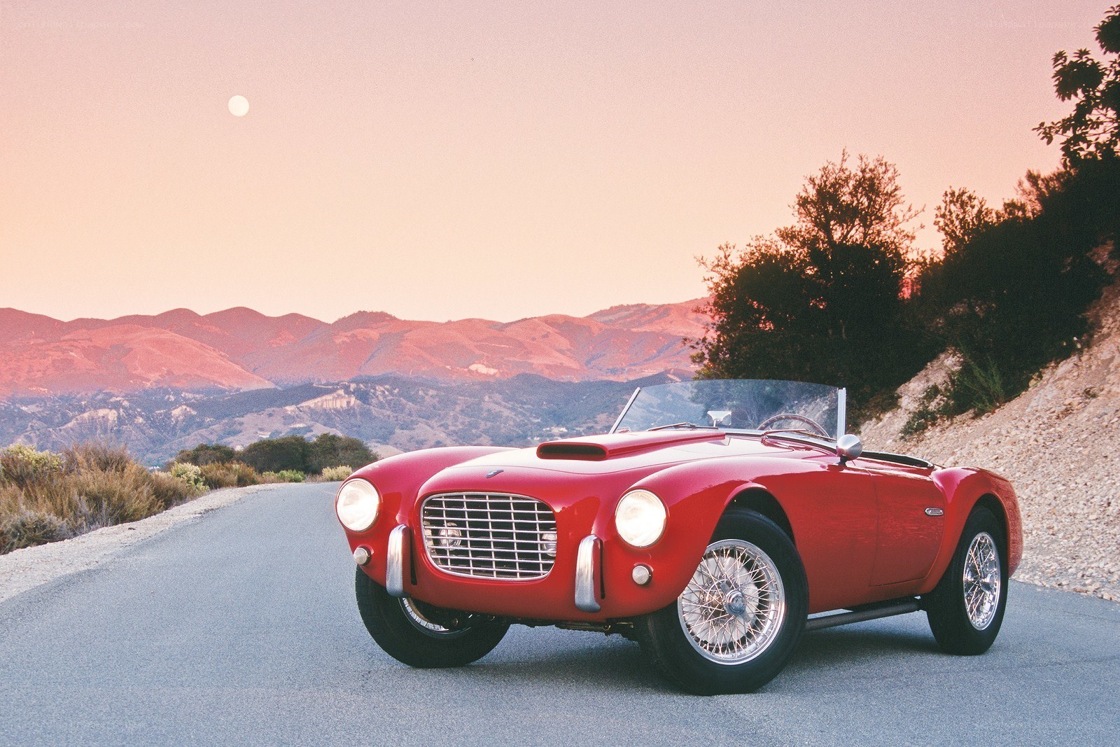 Red classic car on mountain road