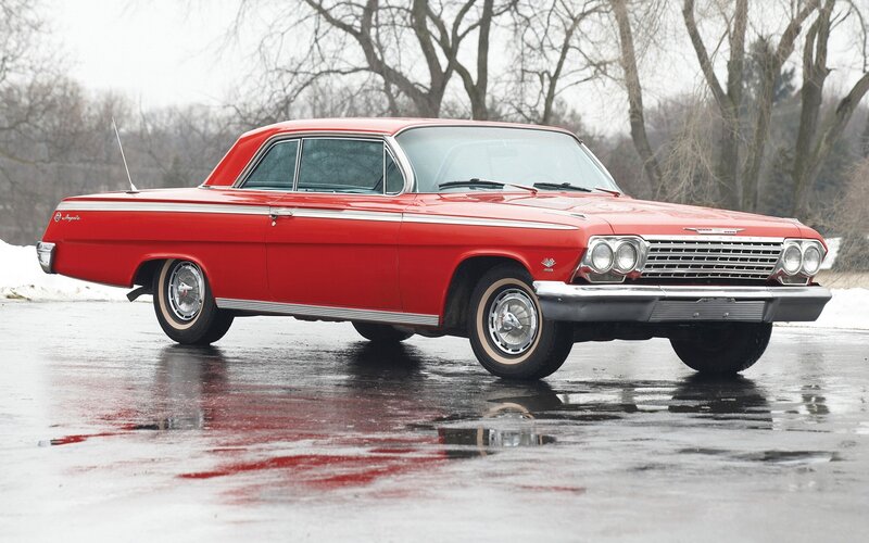 Red classic car on wet pavement