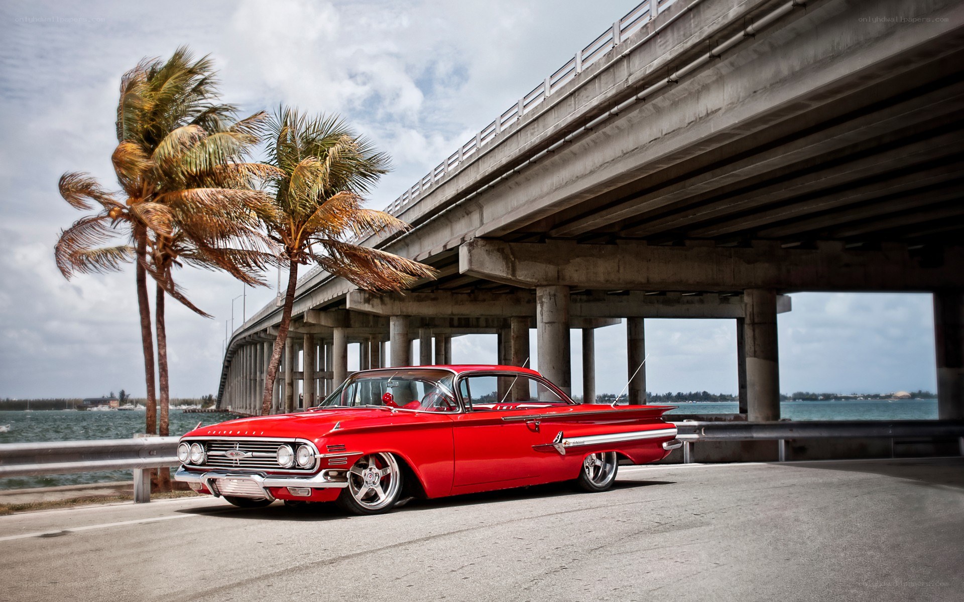 Red classic car under a bridge