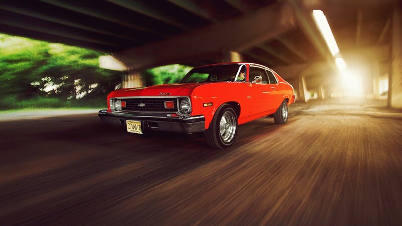 Red classic car under bridge