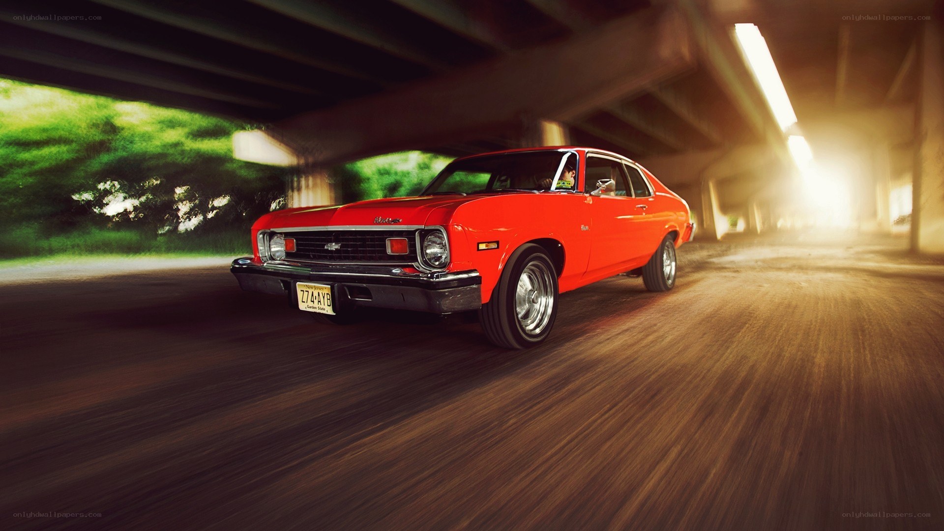 Red classic car under bridge