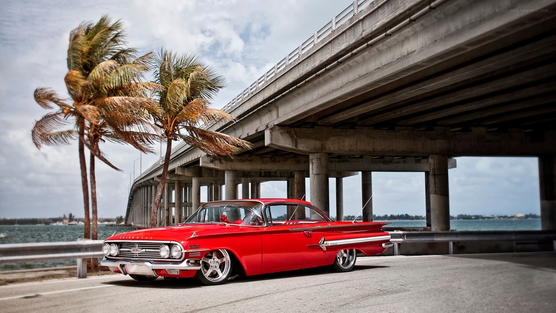 Red classic car under bridge